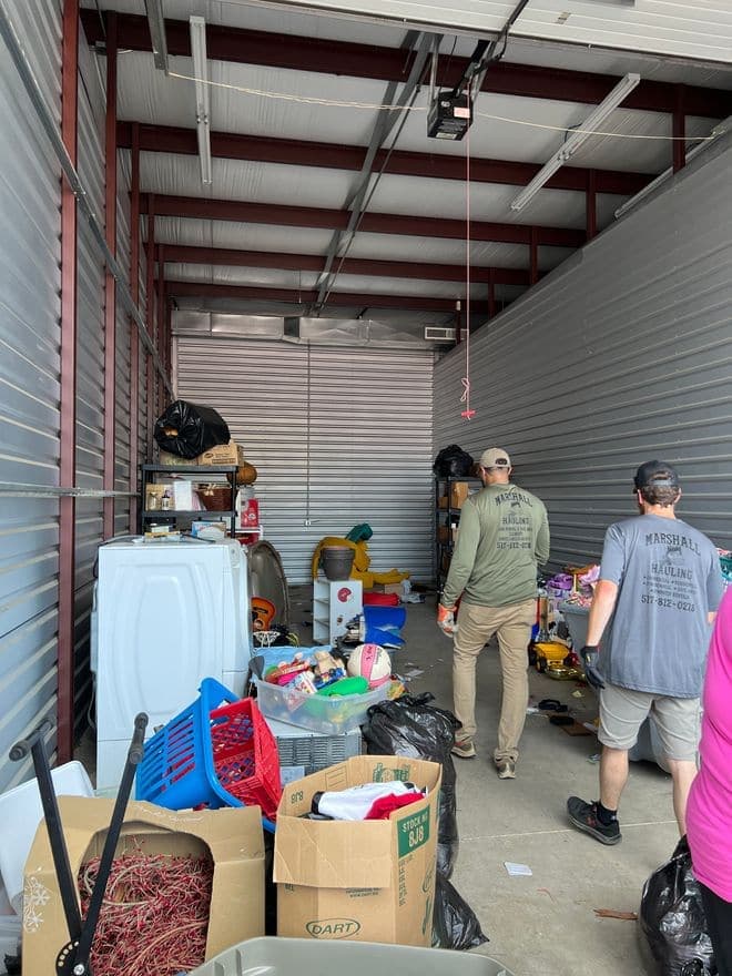 Crew members working through boxes and bins during a storage unit cleanout